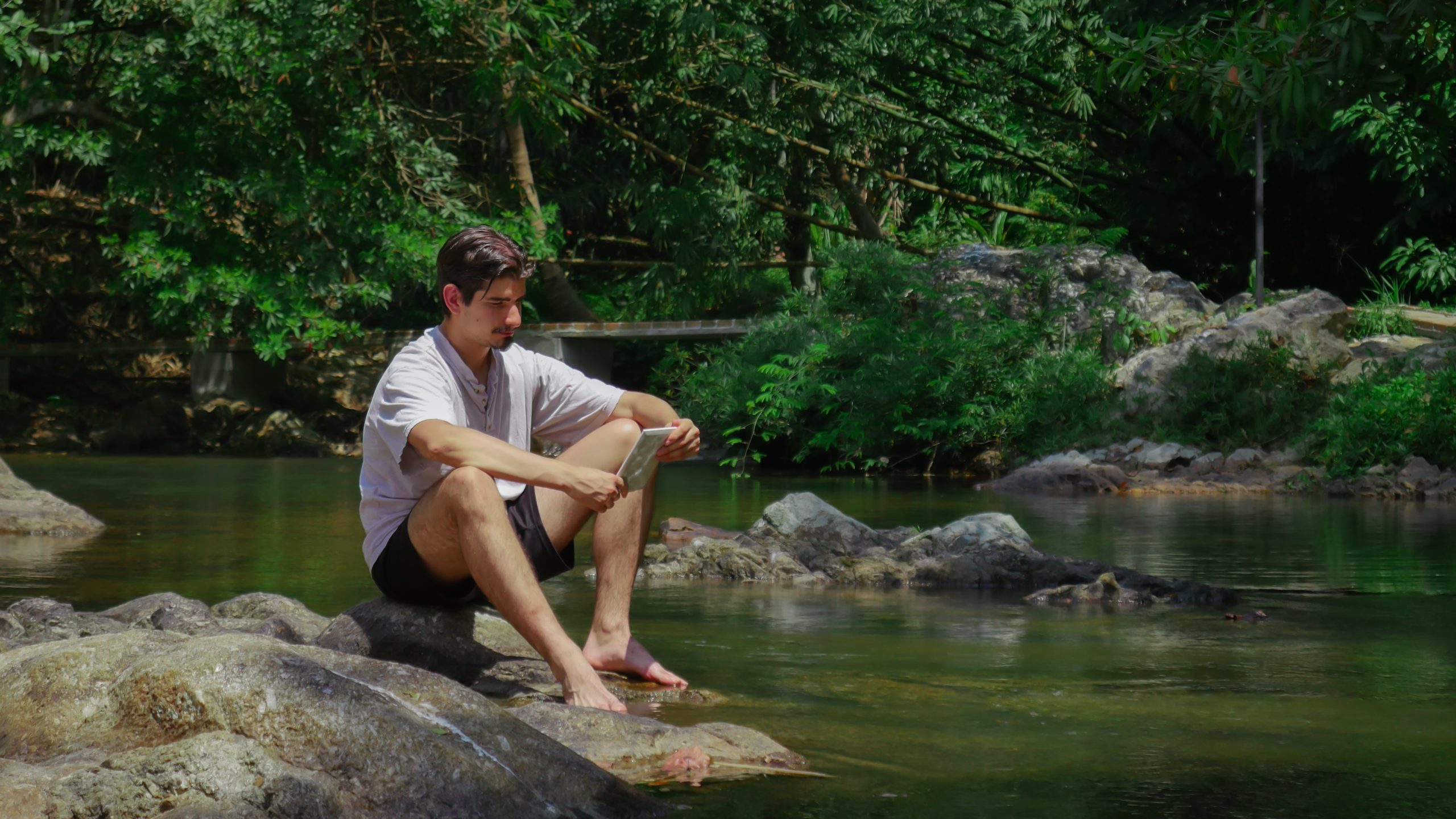Leyendo junto al río en el voluntariado en Tailandia en Oasis Garden